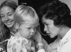 A pediatric nurse practitioner student performs a check-up.	Clinical instructor Beth Lawton & Barbie Dunn, MSN 1974 with pediatric patient. ECBCNHI Barbara Brodie Photograph Collection.