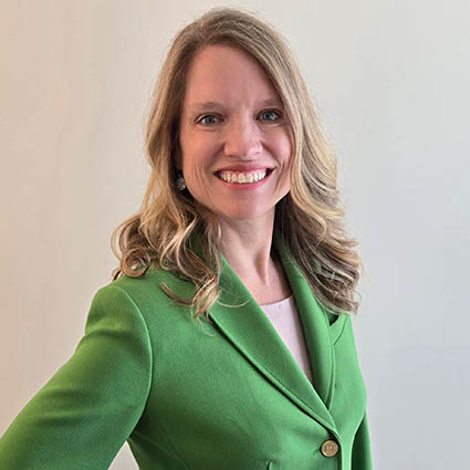 A smiling woman in a green jacket