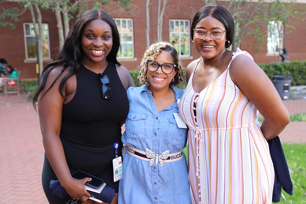 three women standing and smiling