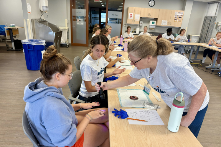 two students participate in a handwashing skills lesson with a faculty member