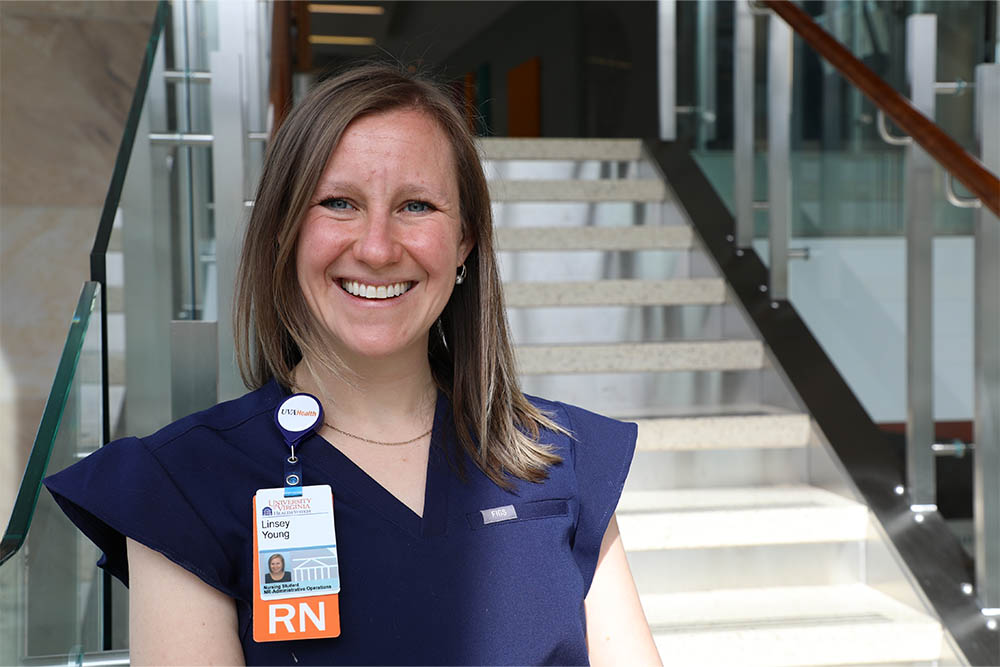 A nurse smiling in a stairwell