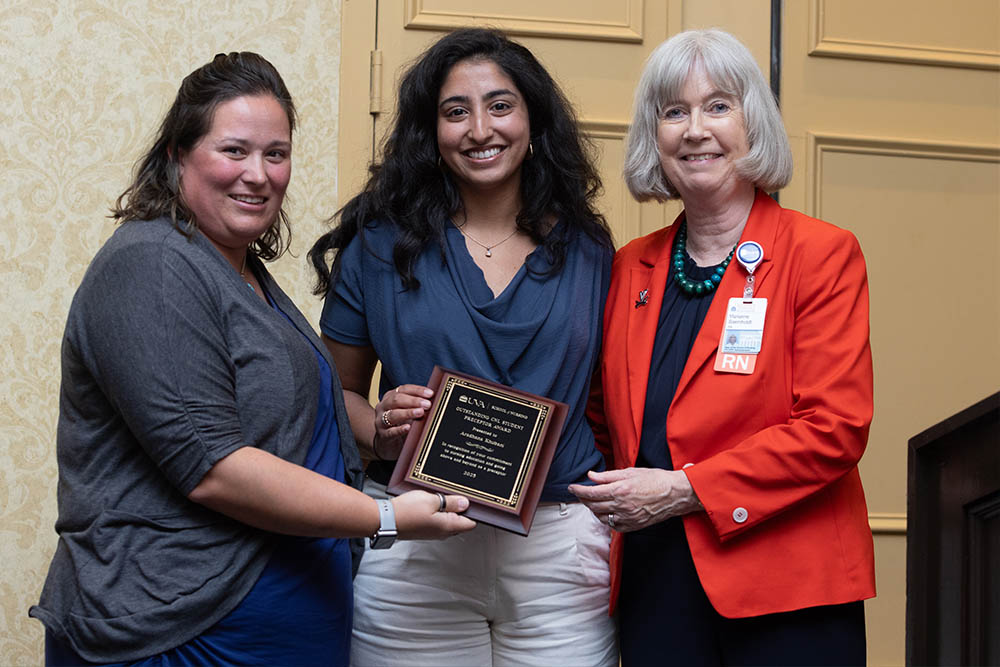 Three women holding a plaque