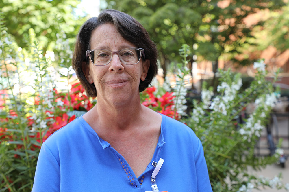 A woman in blue in front of flowers