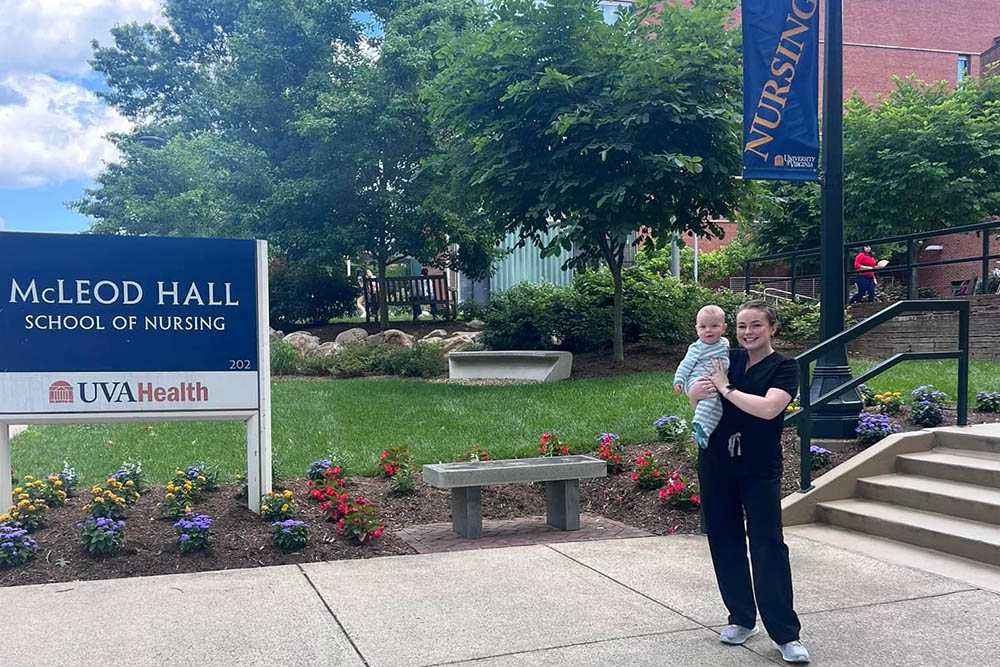 A nurse holding a baby outside