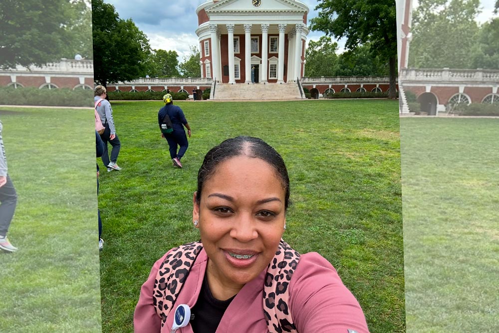 A nursing student in scrubs standing in front of UVA Rotunda